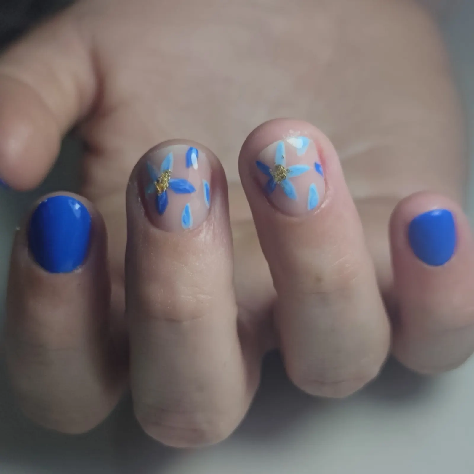 Korte nagels met blauwe bloemen nail art