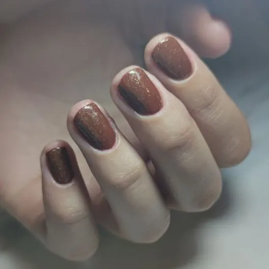 Chocoladebruine nagels met gold flakes topcoat
